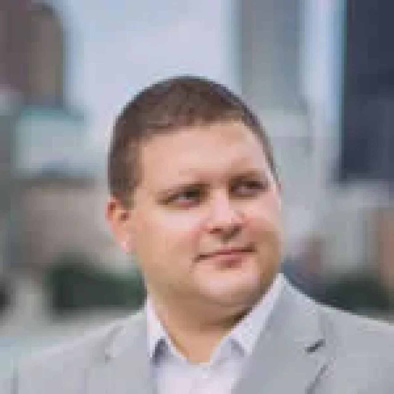 Chad Ruppert, smiling, wearing business attire, with a neutral background