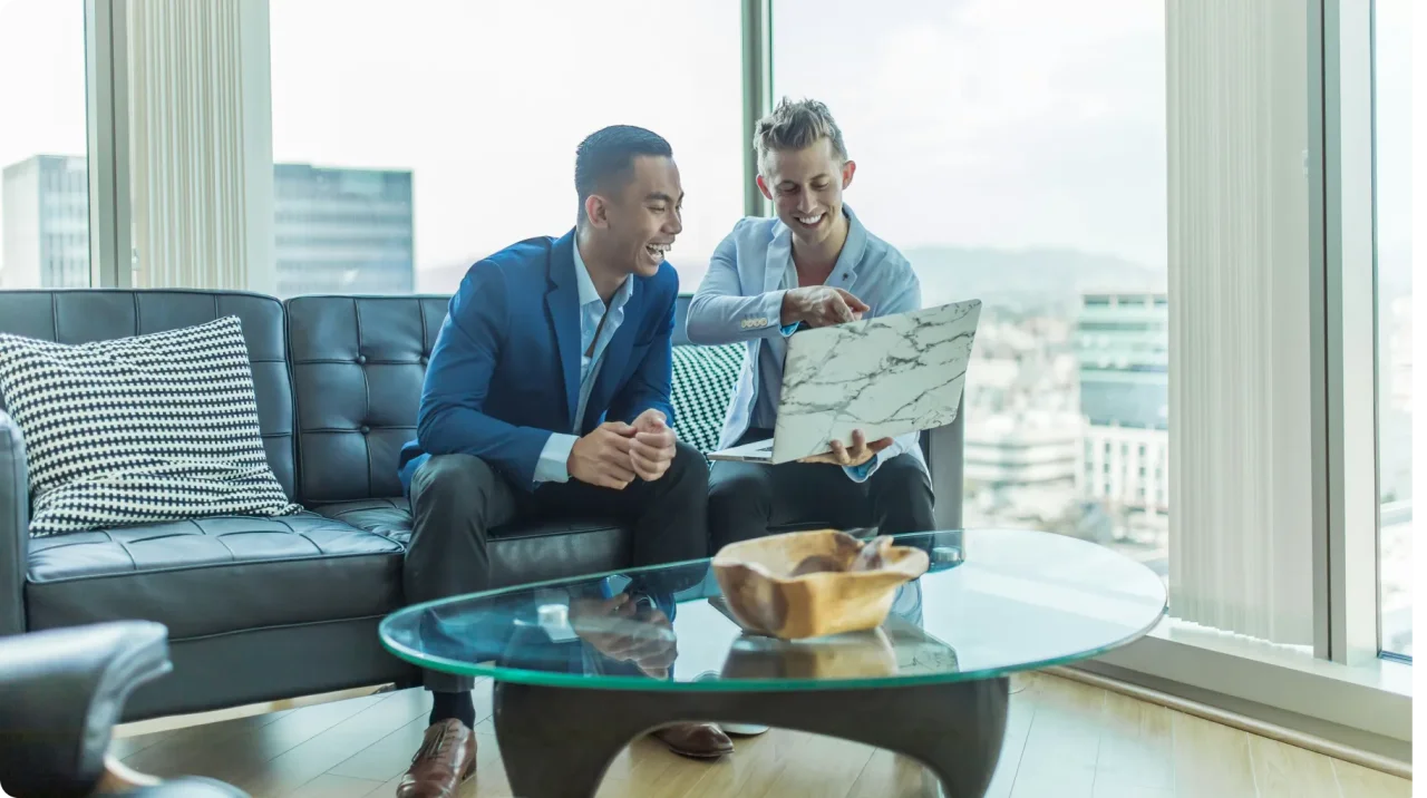 Two Men Sitting On A Couch Beside A Table
