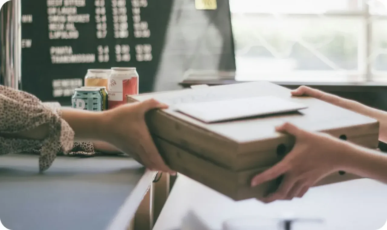 Customer Picking Up Pizza Order At Counter