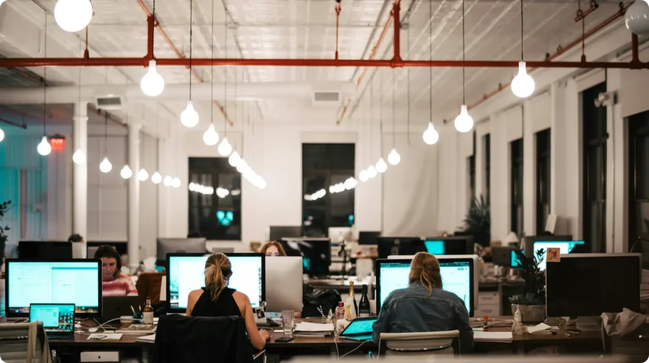 A spacious, well-lit office with people working on computers.