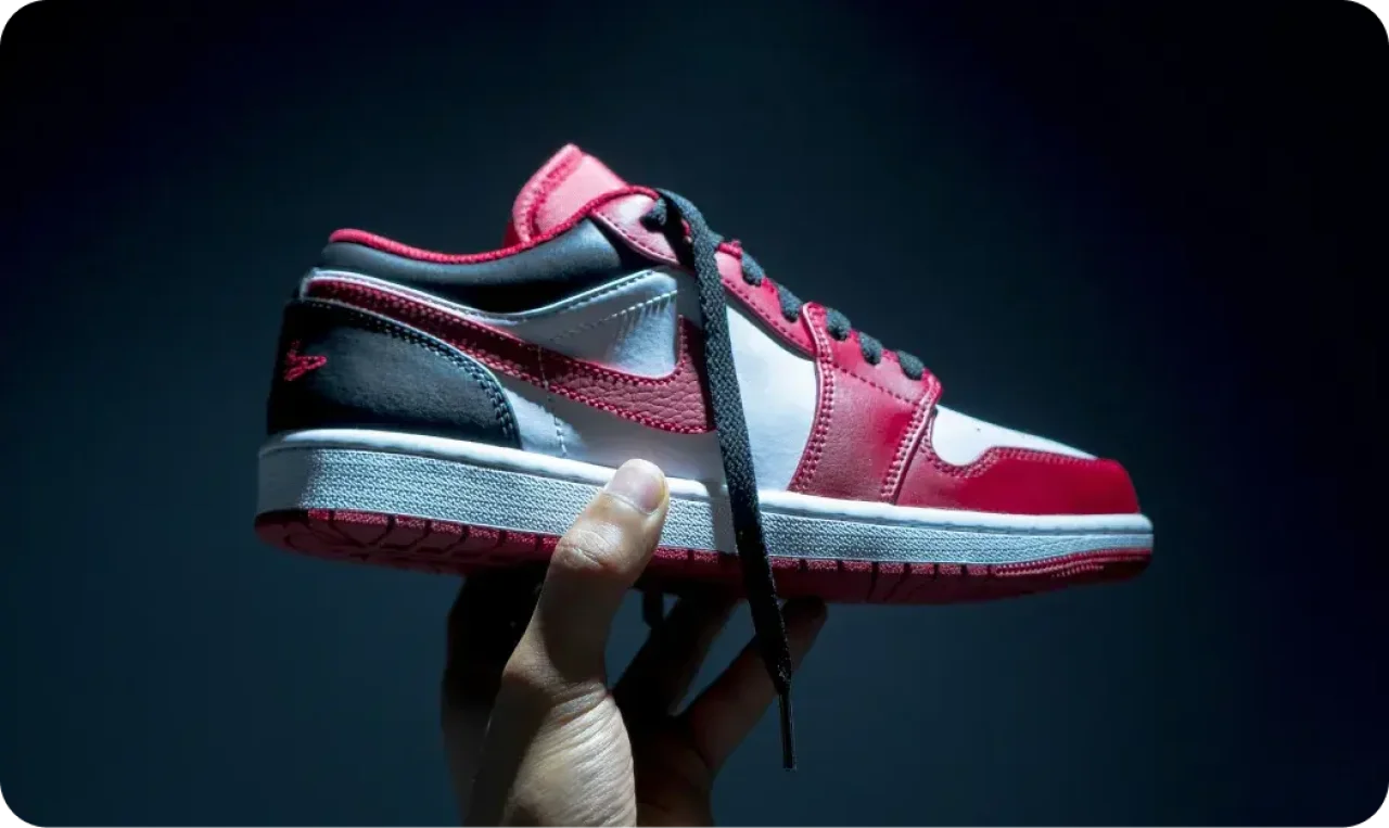 hand-holding-red-and-white-sneaker-in-dramatic-lighting