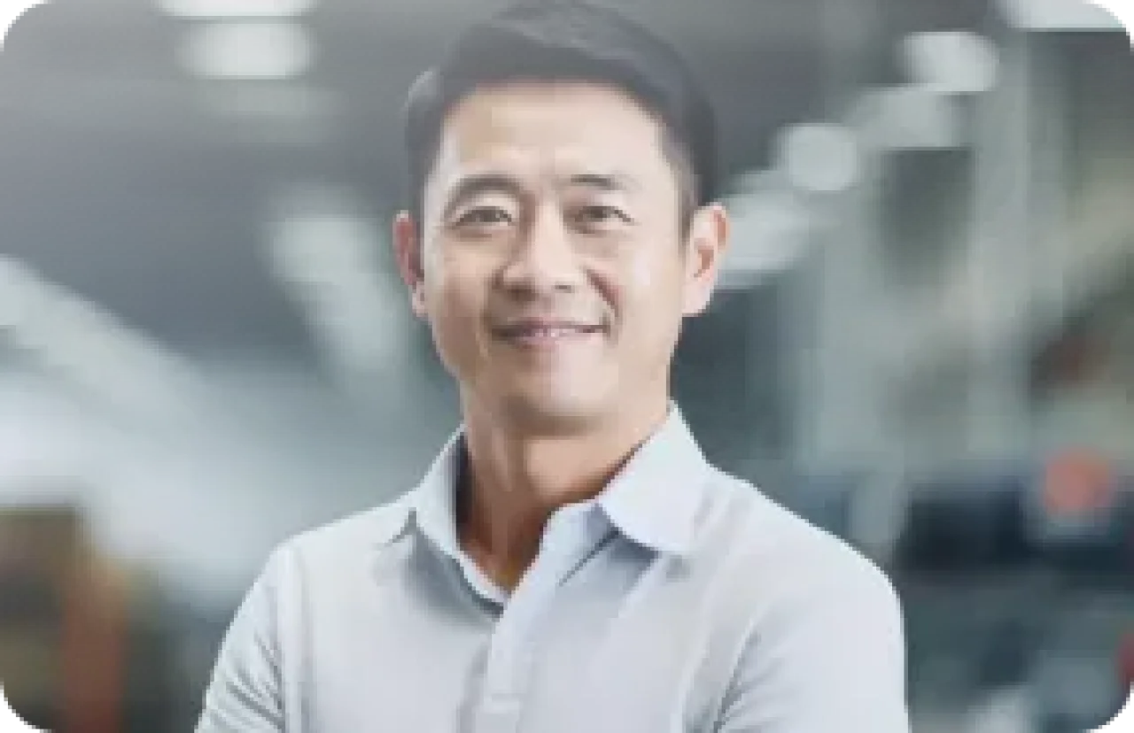 Smiling male professional in a light shirt standing in a modern industrial or warehouse setting